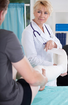 Photo of a doctor in an emergency room applying a leg cast, for Raleigh affordable health insurance from Hunt Insurance.