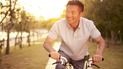 Photo of an Asian man riding a bike, or Raleigh, NC disability income insurance from Hunt Insurance.