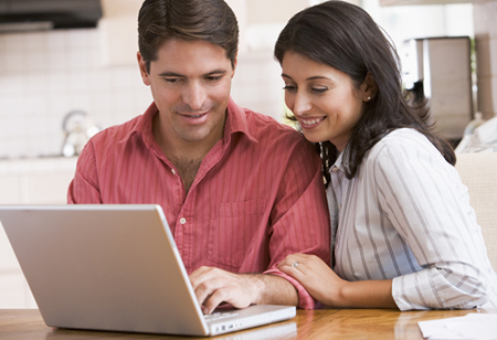 Photo of couple looking at a website on a laptop for information on North Carolina insurance deductibles from Hunt Insurance of Raleigh.