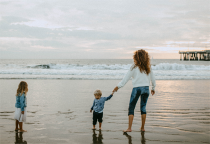 Mom and her son and daughter barefoot at the beach and watching the waves; for information on North Carolina term life insurance from Hunt Insurance.