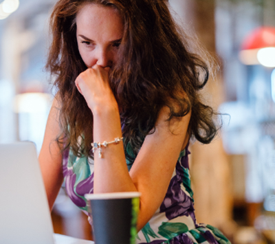 Woman sitting at a laptop and thinking - for information on Raleigh, NC whole life insurance